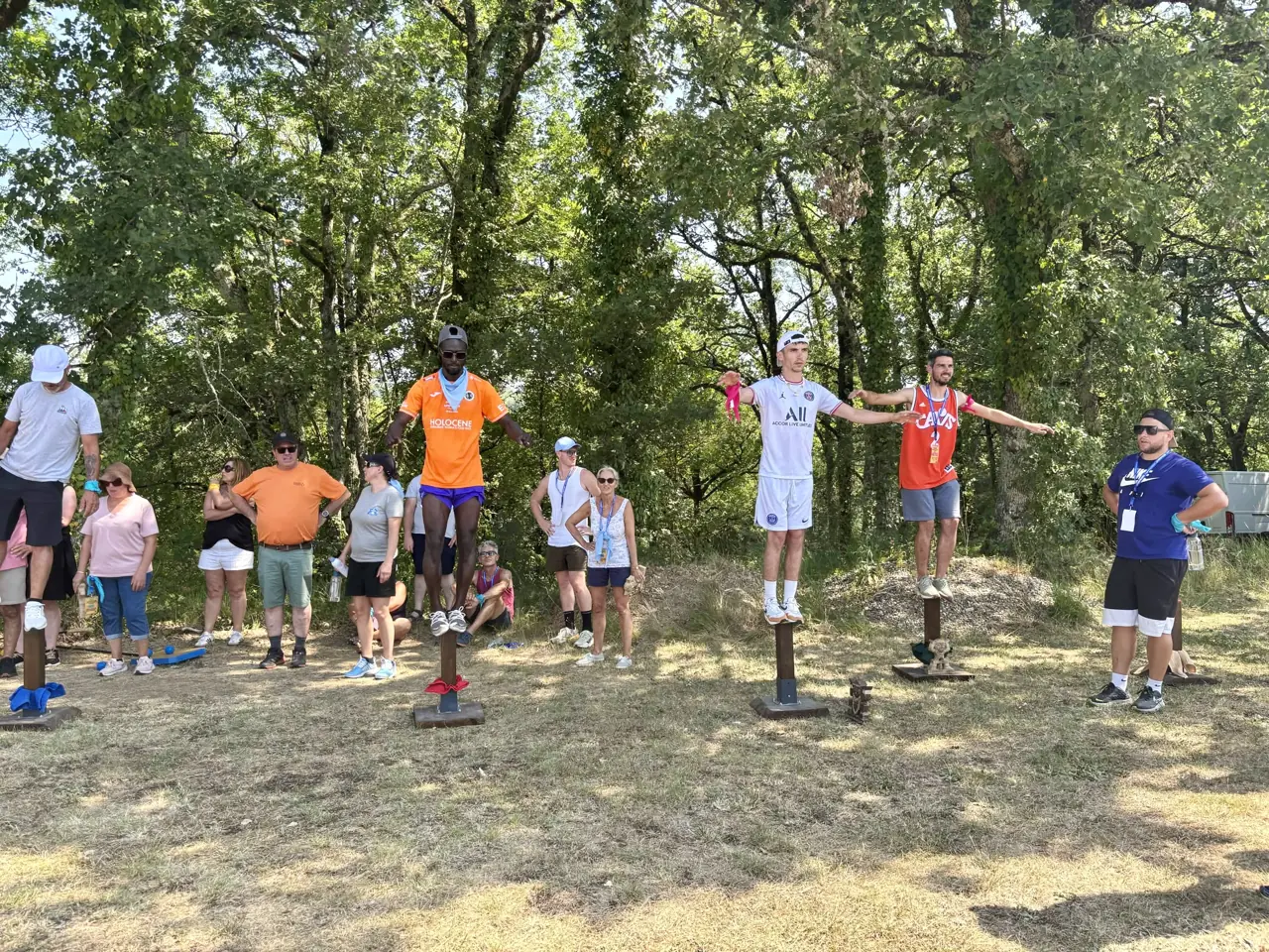 Participants en équilibre sur des poteaux lors du challenge Tribal Quest
